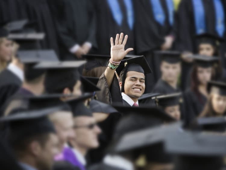 college student waving at graduation