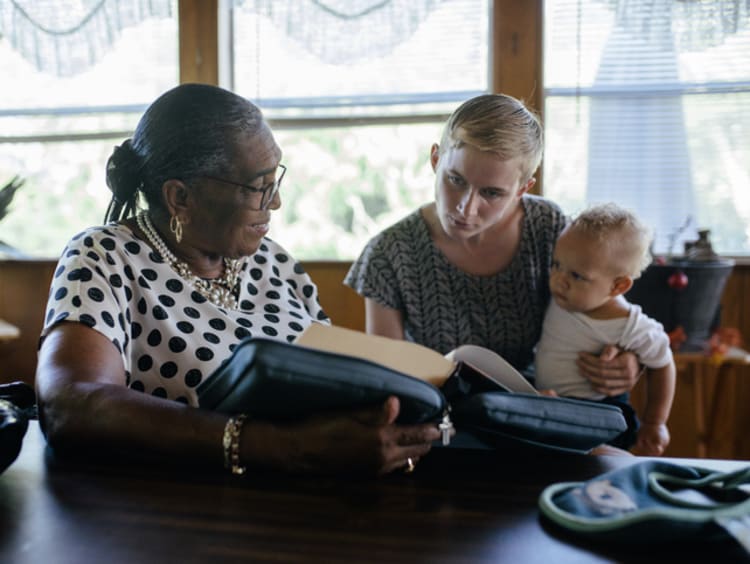 Two women and a baby reading the Bible