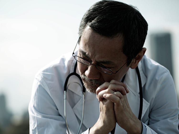 Concerned Doctor Praying