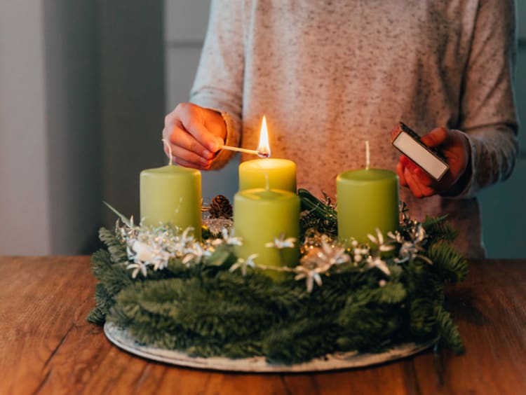Woman lighting four seasonal candles on a table