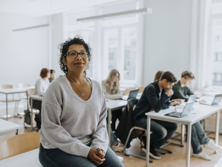 Female teacher sitting in her classroom with students