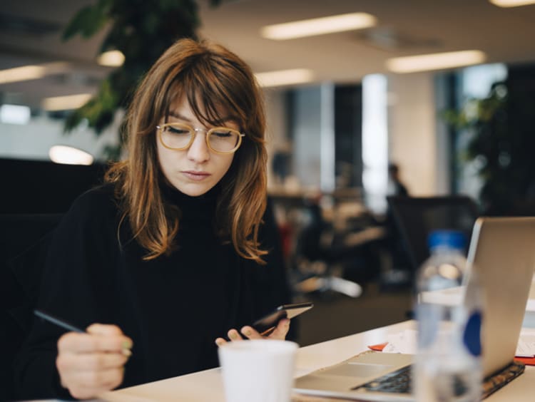 Women writing and sitting with a laptop