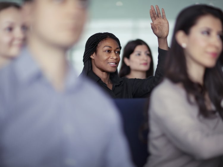DBA and/or MBA student raising hand in classroom