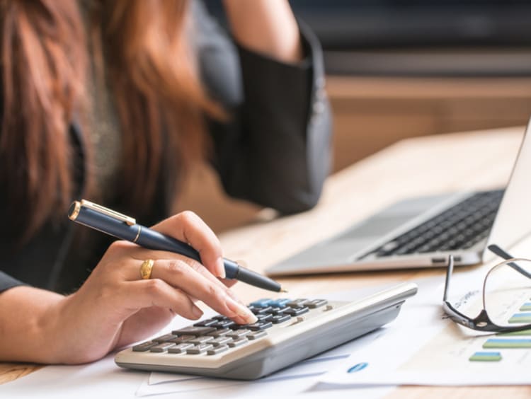 woman's using a calculator and working on laptop