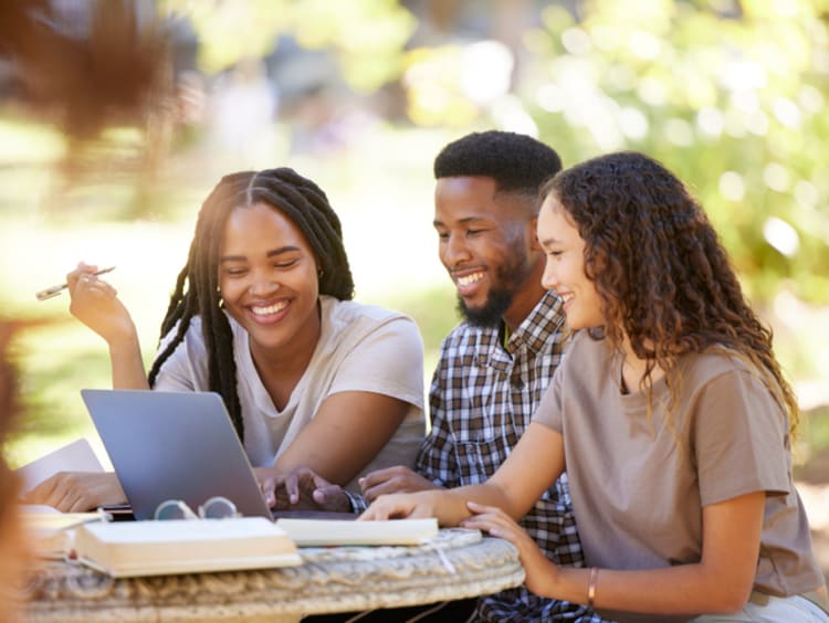 Students, friends and group studying with laptop at park outdoors. Education scholarship, learning teamwork and happy people, black man and women with computer for research at university or college. - stock photo