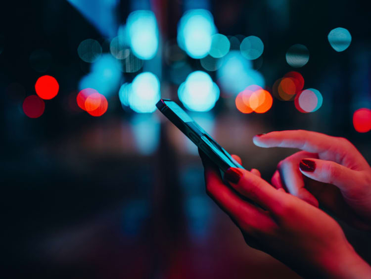 woman holding and using smart phone
