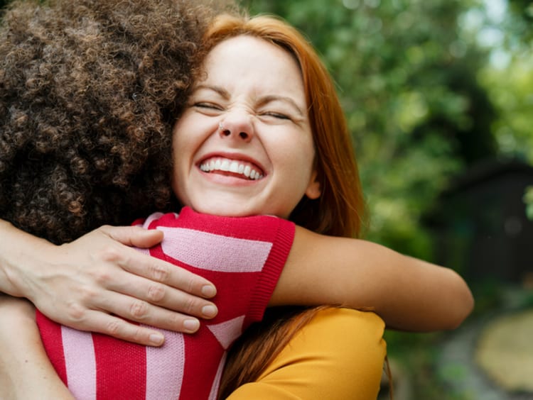 two female friends hugging and smiling