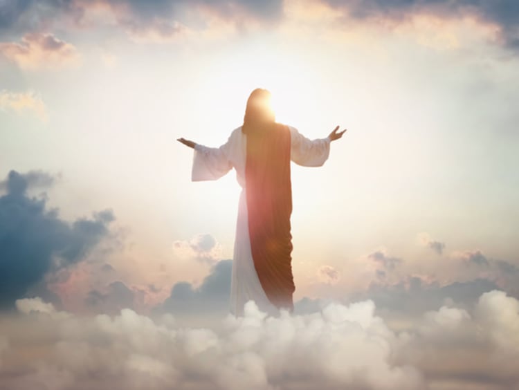 Resurrected Jesus Christ ascending above the sky and clouds, heaven concept - stock photo