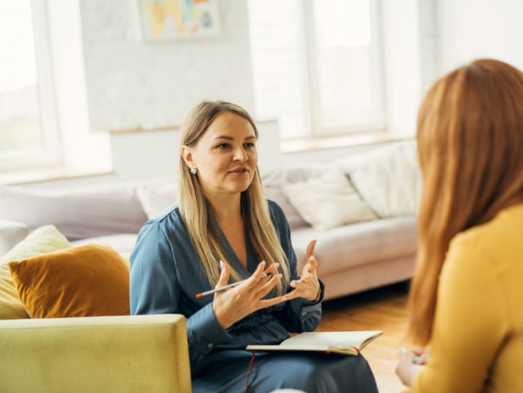 Two women talking and sitting in chairs