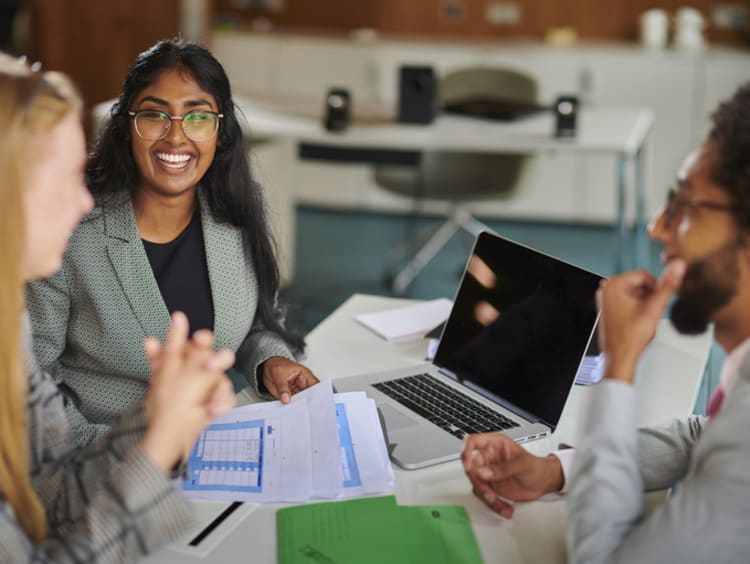 Three coworkers meeting together going over dosuments