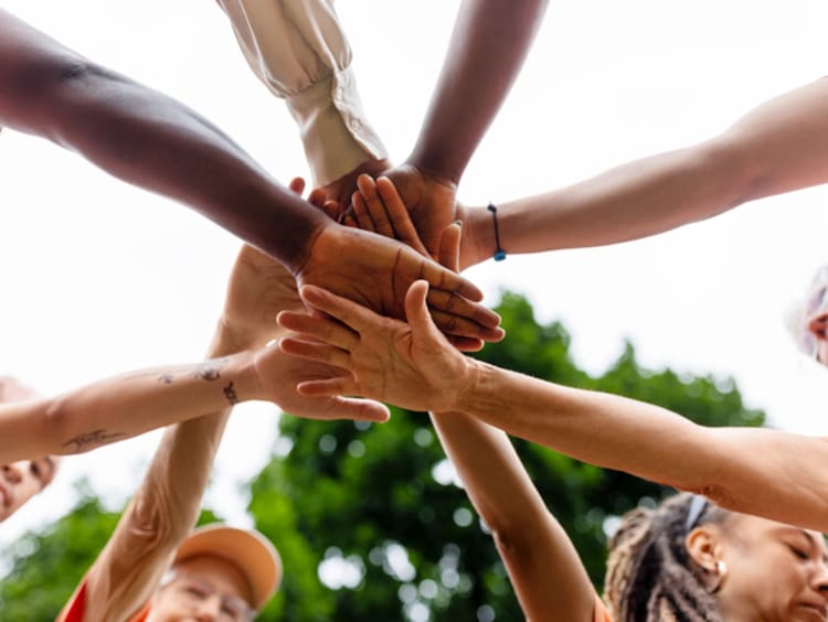 eight people joining hands together as a team