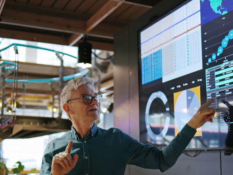 Man pointing and explaining analytics displayed on screen