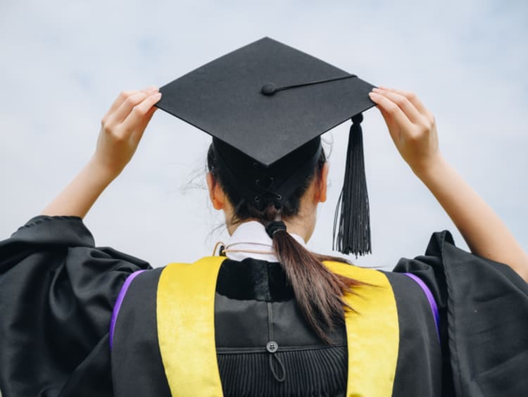 Student wearing graduation cap and gown on commencement day