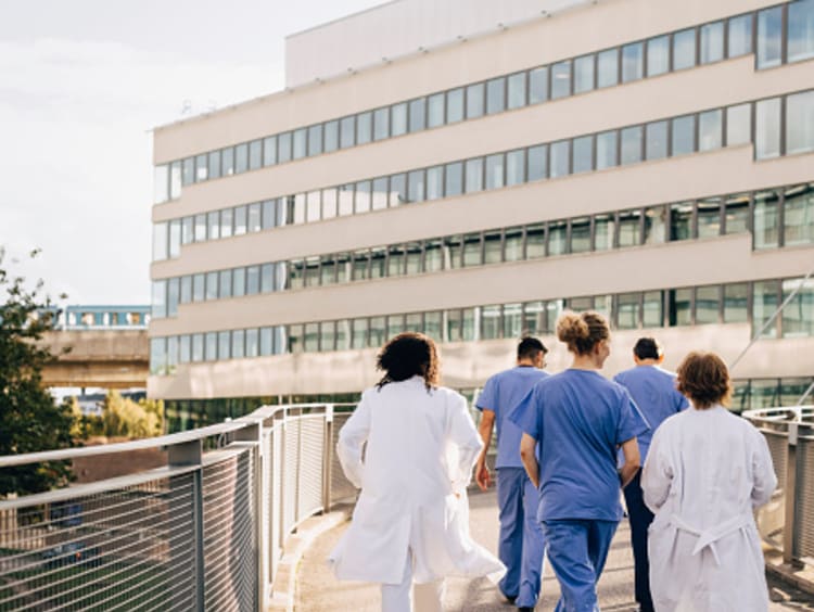 Nurses and Doctors walking into a hospital.
