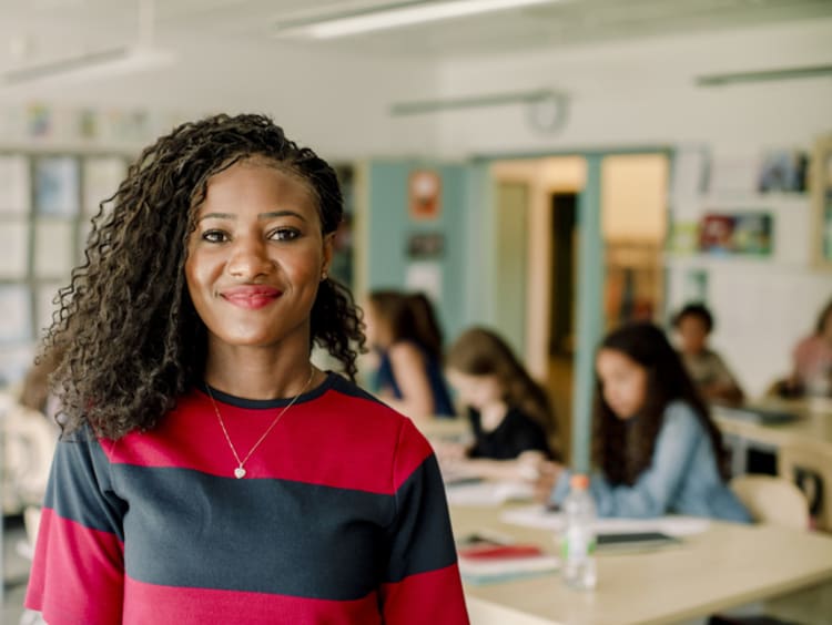 smiling teacher in front of class full of students