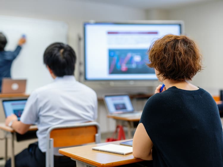 Mid adult woman in a continuing education class at a community college or university - stock photo