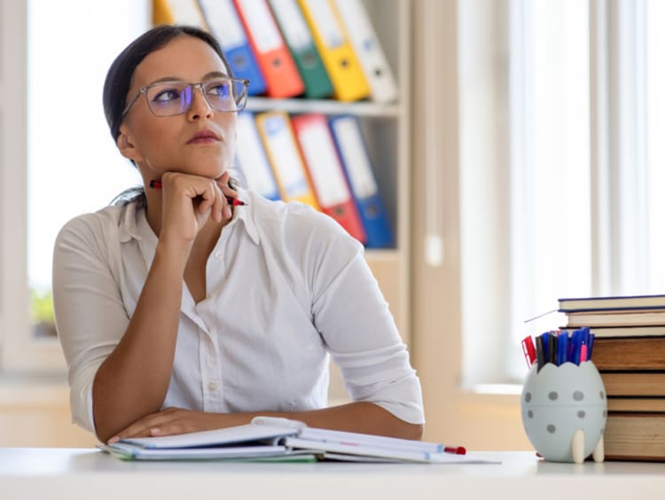 Teacher thinking at her desk