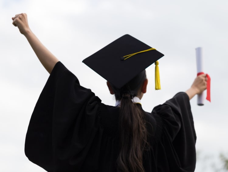 Student in graduation gown celebrating