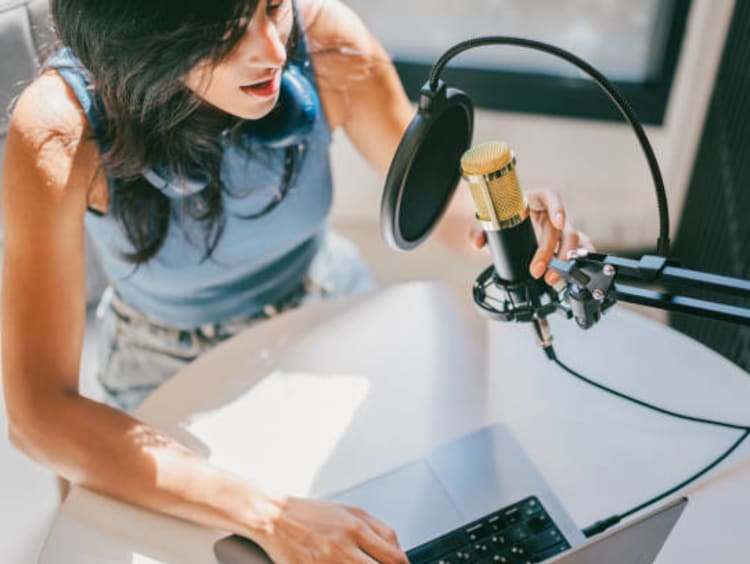 Woman recording on a microphone.
