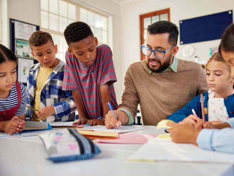 teacher sitting and teaching young students