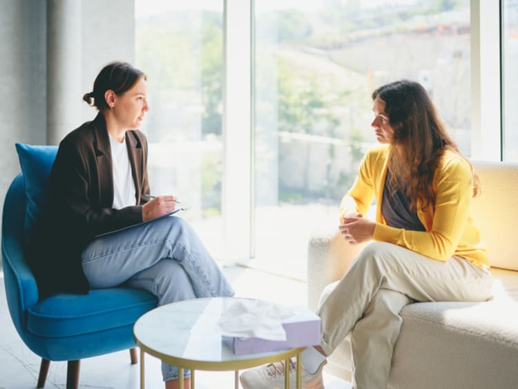 psychologist meeting with a woman and taking notes