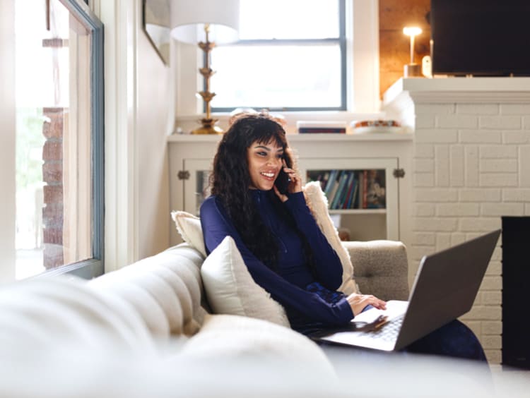 woman on couch at home pursuing an online counseling program in Texas