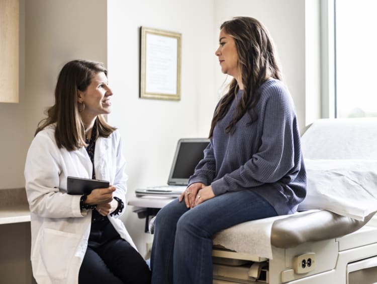 doctor meeting and talking with patient in an exam room