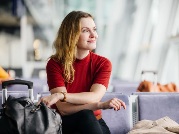 woman waiting patiently in airport smiling