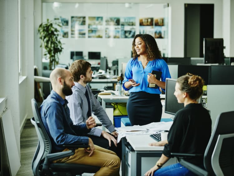 A confident business woman talks to her team.