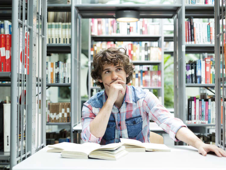 Student ponders at his desk.