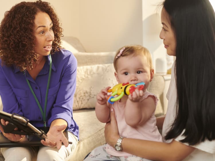 Social worker speaks with mother and baby.