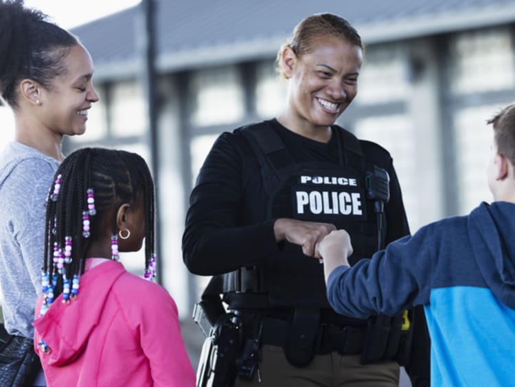 Police officer bumps fists with an 11-year-old.
