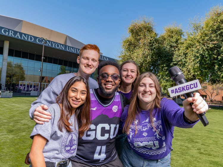 Students outside GCU arena on grass.