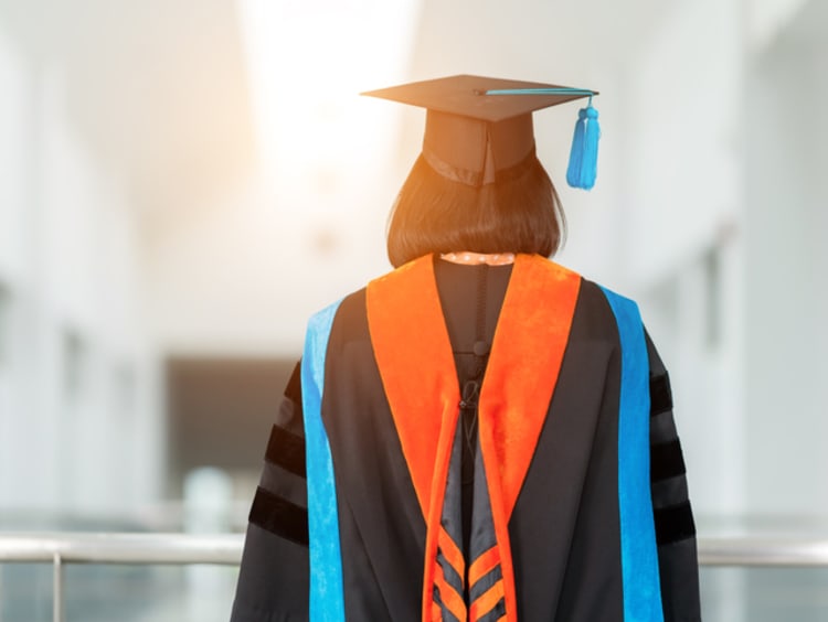 PhD student in cap and gown for graduation