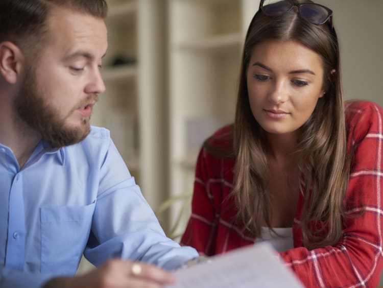 A counselor shows his patient a form.
