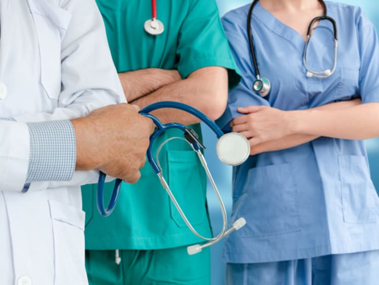 DNP vs NP students in scrubs and white coat holding stethoscope