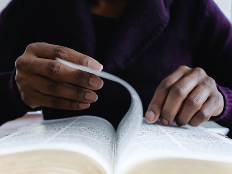 Woman Reading Bible Turns Page - stock photo