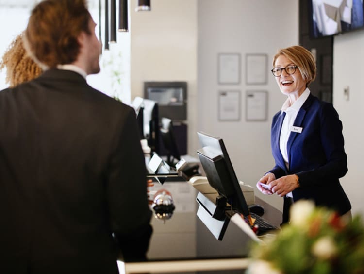 Business couple arriving at hotel reception desk