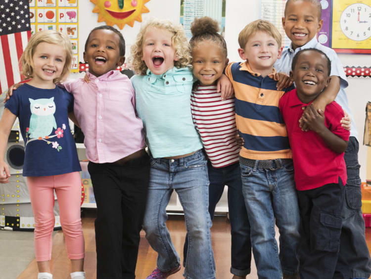 Happy kids gathered together in a classroom.