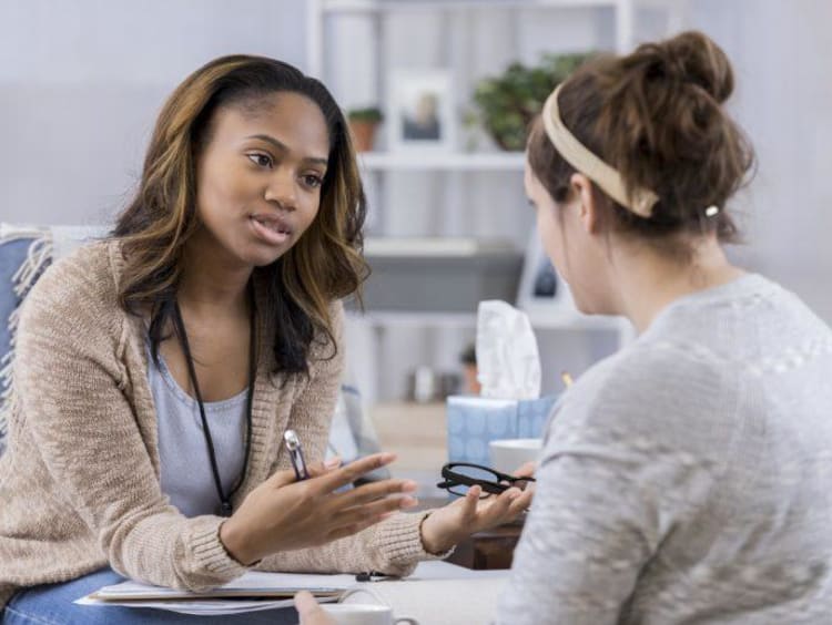 Trauma counselor is in mid-conversation with her female client