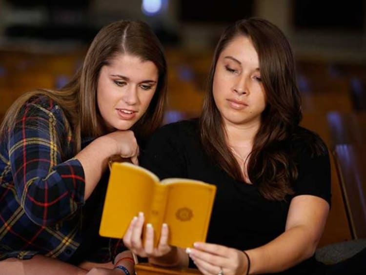 Two young women reading the Bible together