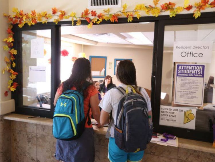 two students at an office window