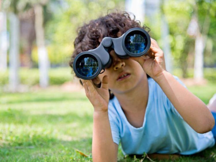 kid looking through binoculars