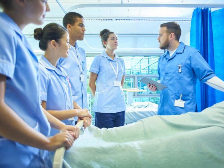 Nursing students by bedside