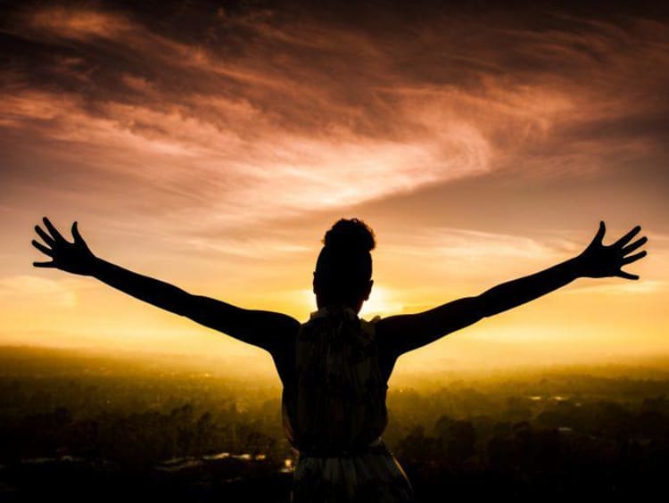 Woman spreading her arms to the sky