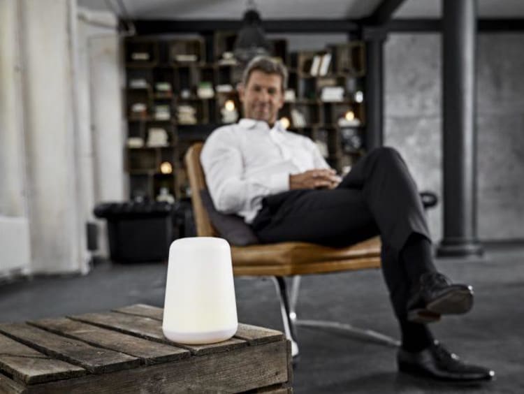 Man sitting beside a digital assistant