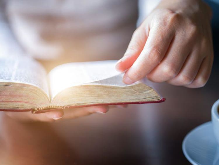 Hand turning a page in the bible