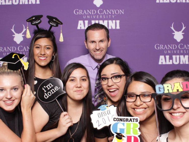 Jim Mostofo poses with recent Education graduates in GCU alumni photo booth