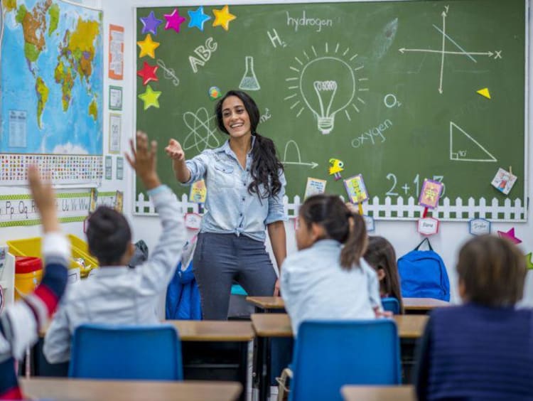 teacher smiling while teaching her students