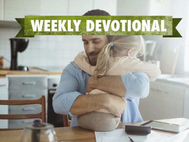 A parent hugging his child under the Weekly Devotional banner